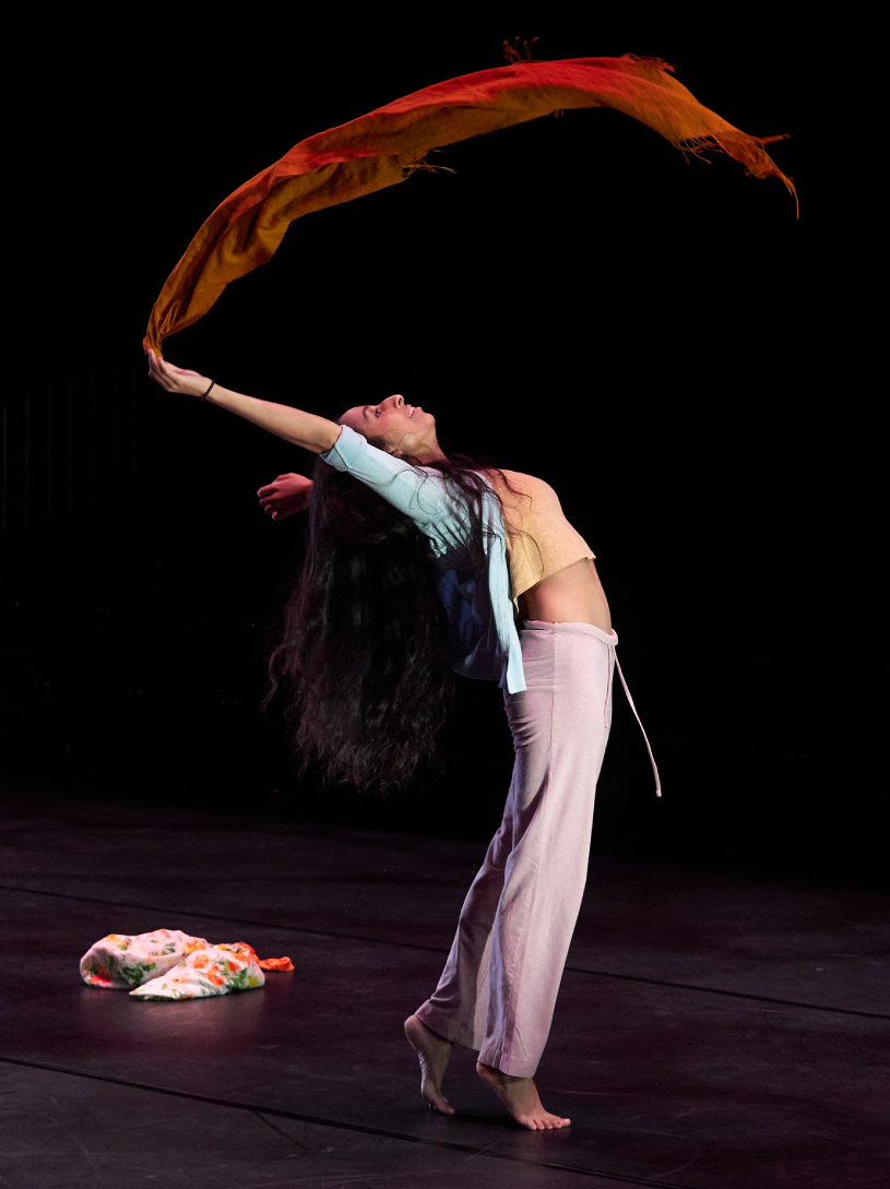a woman throws a scarf into the air