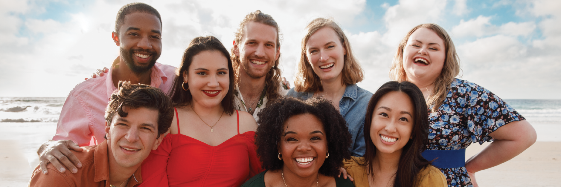 8 people smile in front of a sky background