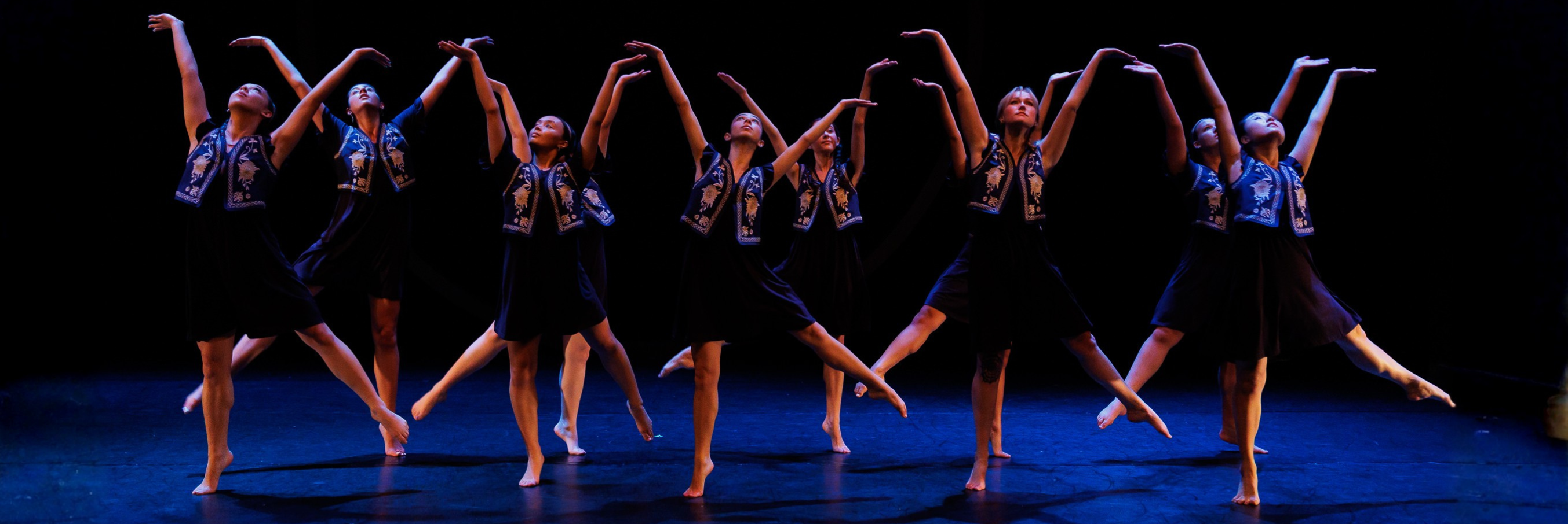 Dancers all in a line posing with arms up